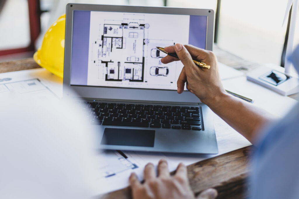 Architects and engineers reviewing digital blueprints for a modern house design