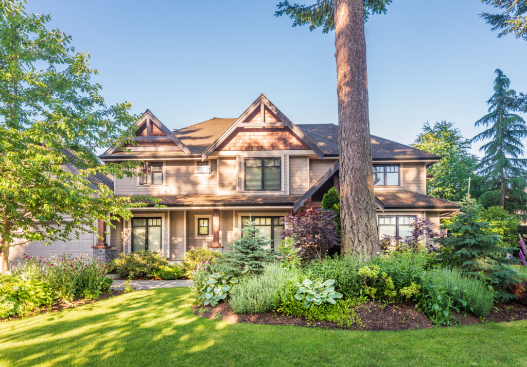 Luxury two story home with large front porch, detailed trim, and landscaped yard